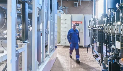 Ein Mitarbeiter von REMONDIS in einer Abfallbehandlungsanlage läuft auf die Kamera zu.